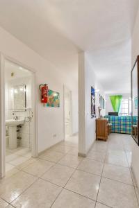 un gran baño blanco con lavabo y espejo en First line beach front 2 bedroom apartment Los Gigantes, en Santiago del Teide
