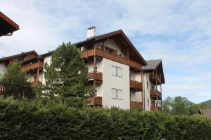 un edificio de apartamentos con balcones y un árbol en Miraval Perathoner Andreas, en Ortisei