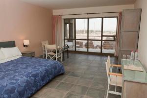 a bedroom with a bed and a table and a kitchen at Azraq Lodge in Al Azraq ash Shamālī