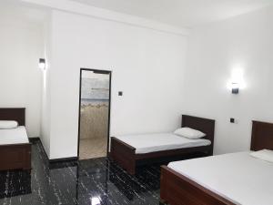 Zimmer mit 2 Betten und einem Spiegel in der Unterkunft Green House Resort in Sigiriya