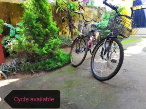 duas bicicletas estacionadas uma ao lado da outra numa rua em David Homes em Cochin