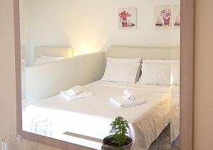 een spiegelbeeld van een bed met twee handdoeken erop bij Galazia Nera Apartments in Áyios Andréas Messinias