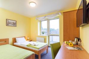 Postel nebo postele na pokoji v ubytování Hotel&Wellness Knížecí rybník