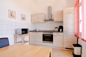a kitchen with white appliances and a wooden table at apartmondo Ferienwohnungen Solingen in Solingen
