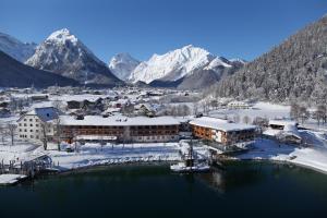 a town in the snow with mountains in the background at aja Fürstenhaus am Achensee in Pertisau