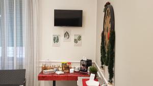 um quarto com uma mesa vermelha e uma televisão na parede em Casantò guest home em Palermo