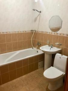 uma casa de banho com uma banheira, um WC e um lavatório. em Inn on Zhytomyrska em Kiev