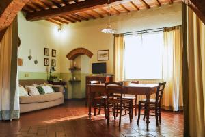 モンテプルチャーノにあるAgriturismo Villa Mazziのリビングルーム(テーブル、椅子、ソファ付)
