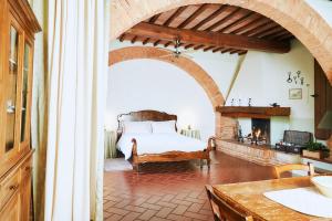 - une chambre avec un lit et une cheminée dans l'établissement Agriturismo Villa Mazzi, à Montepulciano