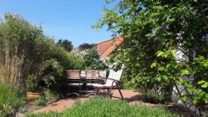 2 sillas y una mesa en un jardín en Ostsee Cottage en Sehlendorf
