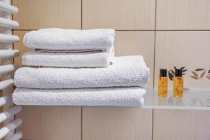 una pila de toallas en un estante del baño en Villavida en Poznan