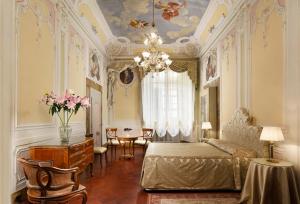 フィレンツェにあるPalazzo Niccolini al Duomo Residenza D'Epocaのベッドルーム1室(ベッド1台、シャンデリア付)