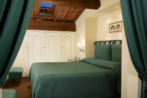 a bedroom with a green bed in a room at Palazzo Niccolini al Duomo Residenza D'Epoca in Florence