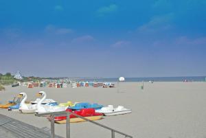 einen Strand mit Booten auf dem Sand und dem Wasser in der Unterkunft Blockhaus mit Parkplatz vor der Haustür in Damp