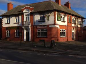 a red brick building on the corner of a street at Gorton Mount Hotel Manchester in Manchester