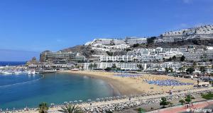 une plage avec un tas de gens et de bâtiments dans l'établissement THE 69, à Puerto Rico