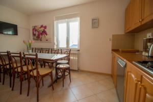 a kitchen and dining room with a table and chairs at Ivanka 2 in Selce