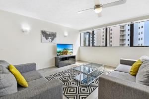 a living room with two couches and a tv at Broadbeach Travel Inn Apartments in Gold Coast
