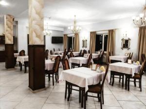 a dining room with white tables and wooden chairs at Paradiso Park in Pobierowo