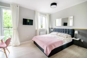 een slaapkamer met een bed met een roze deken bij CANDY ROOM in Olsztyn