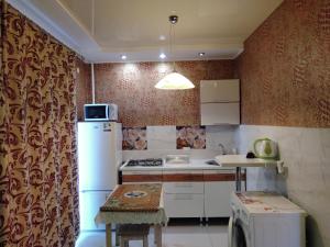 a small kitchen with a refrigerator and a table at Apartments Galactika in Oral