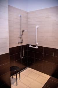 a shower with a black stool in a bathroom at Hotel Artur in Oświęcim