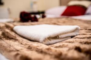 a white towel sitting on top of a bed at Hotel Artur in Oświęcim