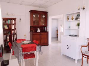 a kitchen with a table and red chairs in a room at Casa Kiko in Playa de Santiago
