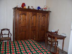 1 dormitorio con armario de madera, mesa y cama en Gite a la campagne, en Mailly-Maillet