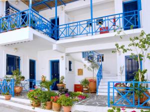 a building with blue doors and potted plants at Electra in Aegina Town