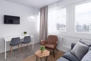 a living room with a couch and a table and chairs at Forenom Serviced Apartments Rauma Kaivopuisto in Rauma