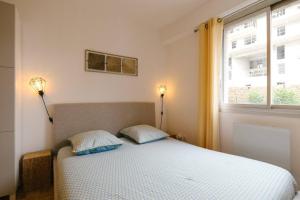 a bedroom with a bed with two pillows and a window at La vie est belle - Longchamps-Canebière-Gare in Marseille