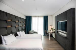 Cette chambre comprend deux lits et une télévision. dans l'établissement Wish More Hotel Istanbul, à Istanbul