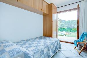 1 dormitorio con 1 cama y puerta corredera de cristal en Villa Cadí . Ref. 620, en Tamariu