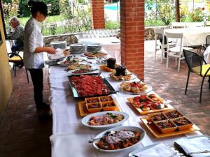 una mesa con muchos platos de comida. en Le Camere del Relais La Pieve Vecchia, en Riparbella