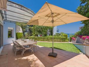 a patio with a table and an umbrella at Aegean Residence #A - F & B Summer Collection in Kallithea Halkidikis
