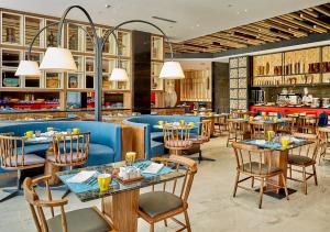 a dining room with tables and chairs in a restaurant at Dusit Thani Shuangyue Bay Resort Huizhou in Huidong