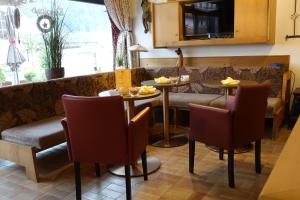 a restaurant with two tables and a couch at Hotel Bergland in Sillian