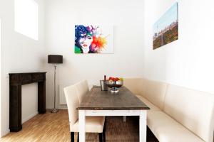 une salle à manger avec une table et un canapé dans l'établissement SC 02 by ROCKCHAIR Apartments l SUPERHOST Status l 4 Bedrooms Boxspringbeds 2 Bathrooms Balcony Elevator - Cozy Family & Business Flair welcomes you!, à Berlin