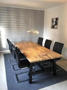 comedor con mesa de madera y sillas negras en Apartement Merlin, en Wilhelmshaven