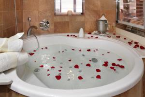 a bath tub filled with red hearts in a bathroom at Hotel Spa Porto Cristo in Port de la Selva