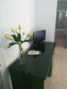 a black desk with a vase of flowers on it at Hotel Restaurante Logasasanti in Andújar