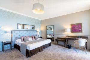 a hotel room with a large bed and a desk at Hôtel Le Royal Promenade des Anglais in Nice +37 photos