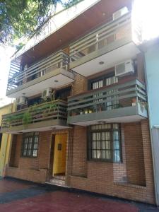 un gran edificio de ladrillo con puerta amarilla en Cálido Departamento a una cuadra de Aristides en Mendoza