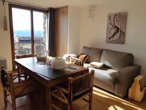 a living room with a table and a couch at Le Grizzly Luxe Location in Font-Romeu