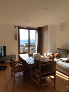 a living room with a table and a couch at Le Grizzly Luxe Location in Font-Romeu