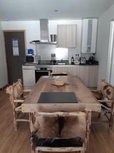 eine Küche mit einem Holztisch mit Stühlen in der Unterkunft Le Grizzly Luxe Location in Font-Romeu