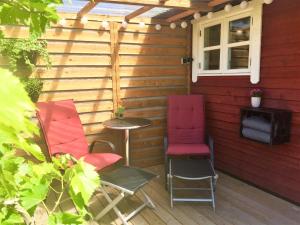 a red chair sitting in front of a patio chair at Ølholm Cottage in Stege
