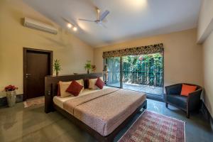 a bedroom with a bed and a window and a chair at SaffronStays Masaya, Alibaug - pet-friendly villa with alfresco dining in Alibaug