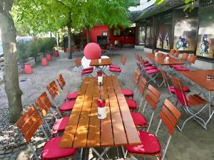 a wooden table and chairs with red cushions on a patio at Michel Hotel Wetzlar in Wetzlar